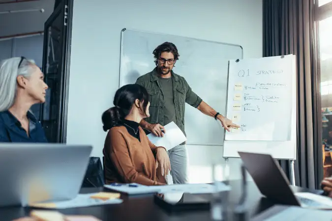 Marketing lead presenting Q1 strategy to colleagues in a meeting.